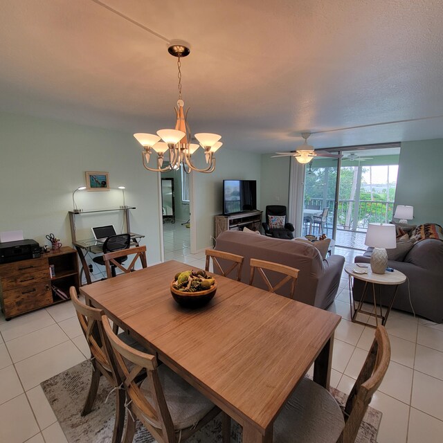 tiled dining room featuring a textured ceiling and ceiling fan with notable chandelier