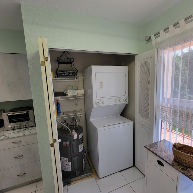 laundry room featuring light tile patterned floors and stacked washer and clothes dryer