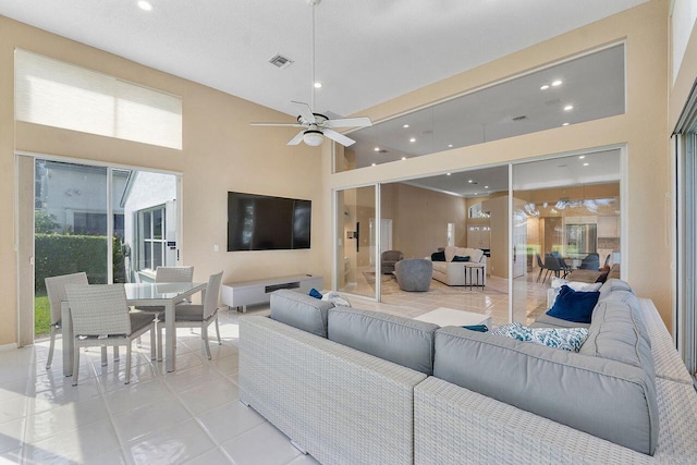 tiled living room featuring a towering ceiling and ceiling fan