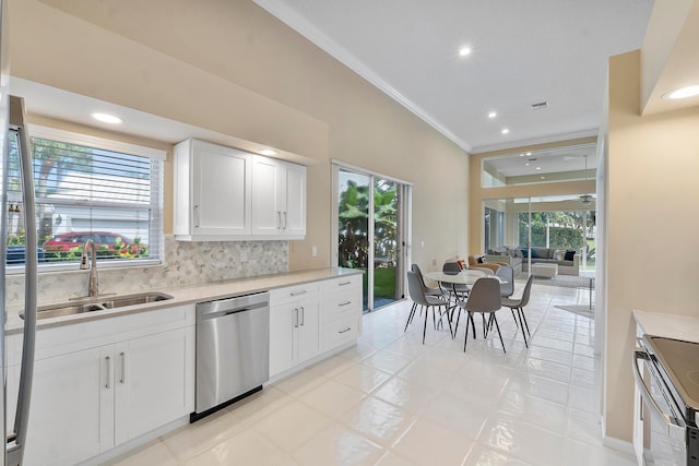 kitchen with stainless steel appliances, white cabinets, plenty of natural light, and sink