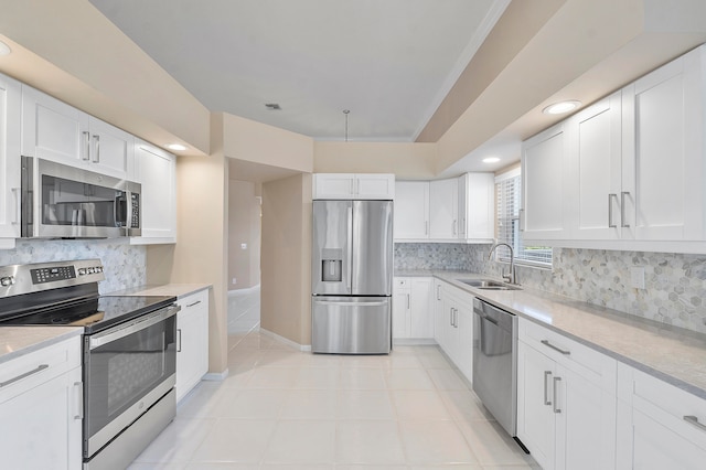 kitchen with appliances with stainless steel finishes, sink, tasteful backsplash, and white cabinetry