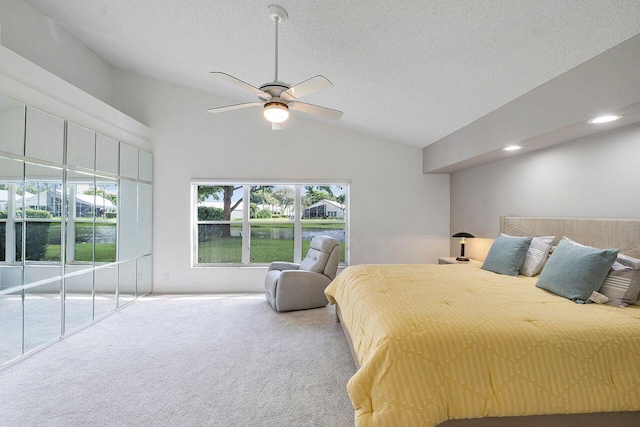 carpeted bedroom with a textured ceiling, lofted ceiling, and ceiling fan