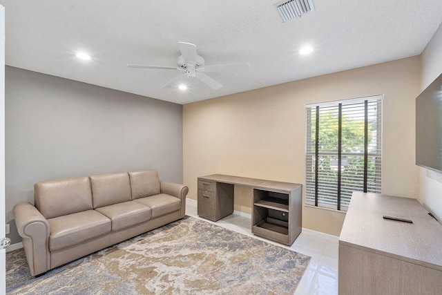 tiled living room featuring a textured ceiling and ceiling fan