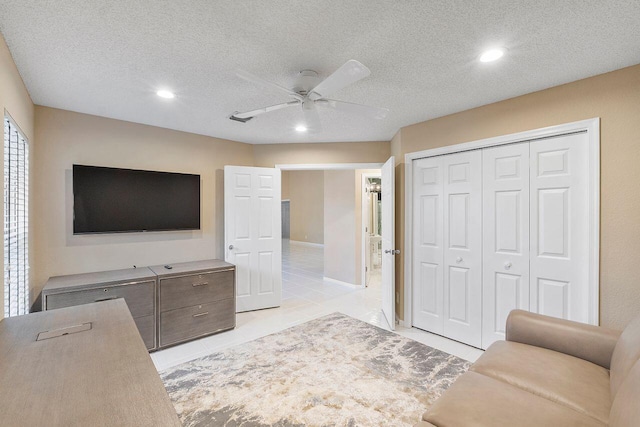 unfurnished living room with a textured ceiling, light tile patterned floors, and ceiling fan