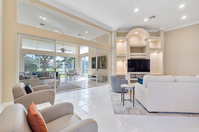 tiled living room featuring crown molding and ceiling fan