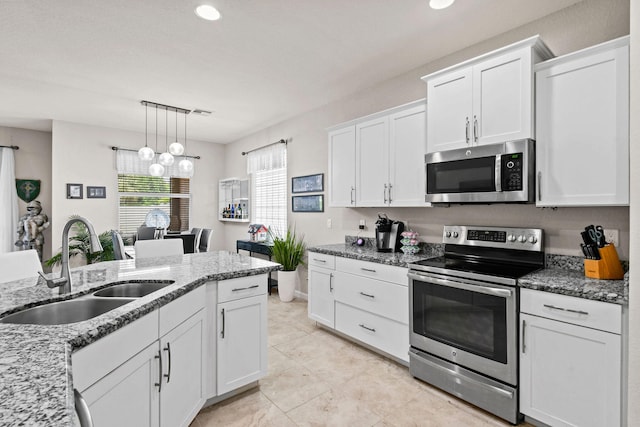 kitchen with sink, decorative light fixtures, appliances with stainless steel finishes, and white cabinets