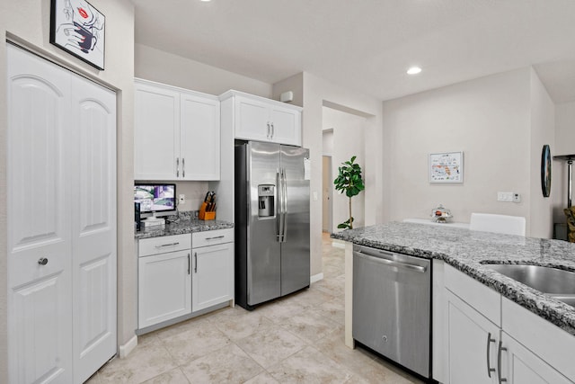 kitchen featuring appliances with stainless steel finishes, white cabinetry, light tile patterned floors, and light stone countertops