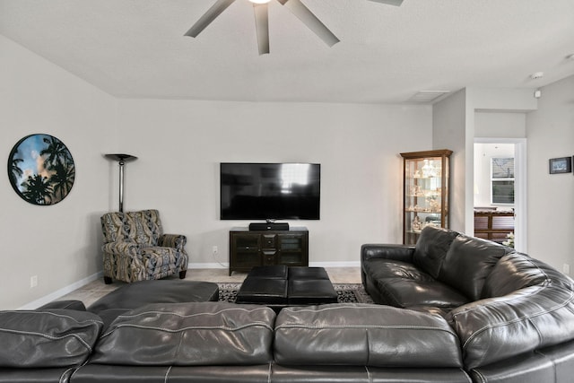 living room with a textured ceiling and ceiling fan