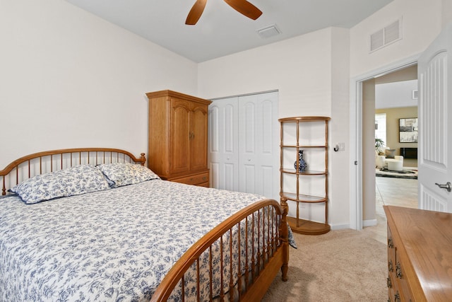 bedroom with a closet, ceiling fan, and light carpet