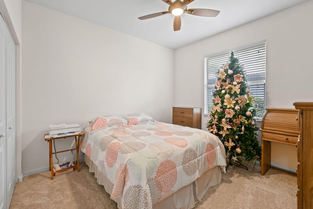 bedroom with a closet, ceiling fan, and light colored carpet