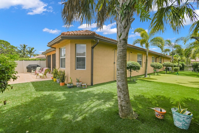 view of side of home featuring a lawn and a patio