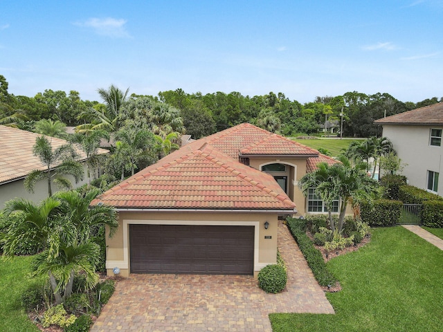 mediterranean / spanish house with a garage and a front yard