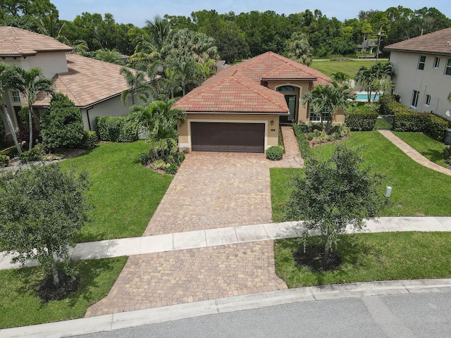 mediterranean / spanish house featuring a garage and a front lawn