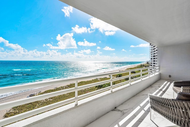 balcony featuring a water view and a beach view