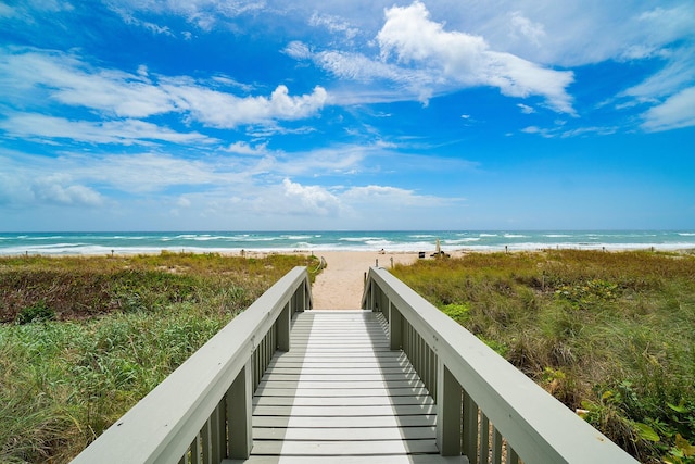 view of property's community with a beach view and a water view