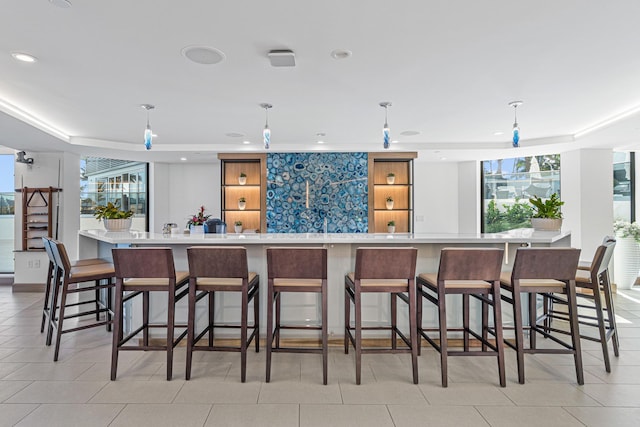 kitchen featuring pendant lighting, a large island, a breakfast bar, and light tile patterned floors