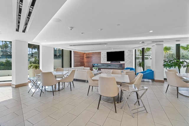 dining space with light tile patterned flooring, floor to ceiling windows, and a fireplace