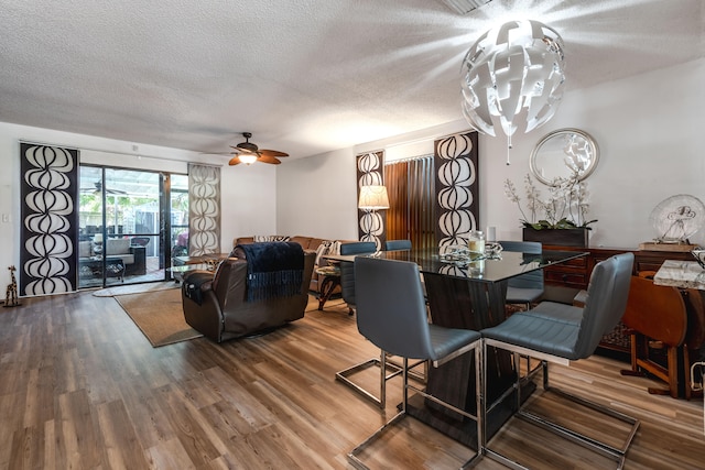 dining area featuring a textured ceiling, hardwood / wood-style floors, and ceiling fan