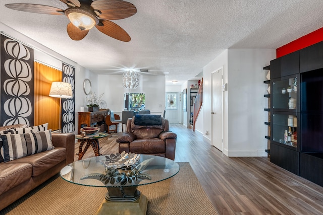 living room with a textured ceiling, hardwood / wood-style floors, and ceiling fan