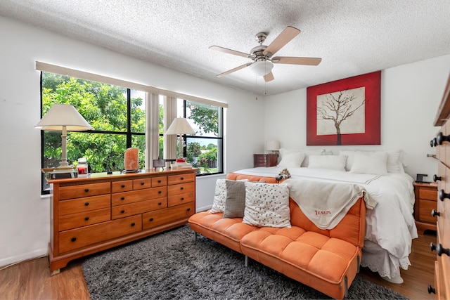 bedroom featuring a textured ceiling, ceiling fan, and hardwood / wood-style floors