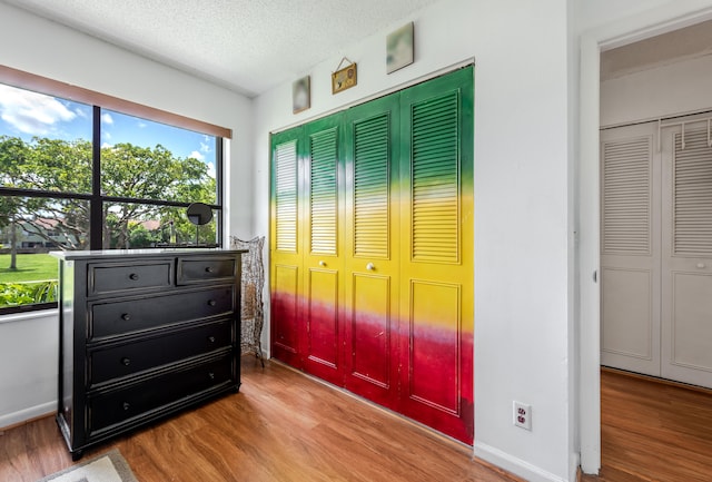 bedroom with a closet, wood-type flooring, and a textured ceiling