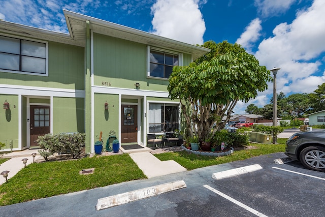 townhome / multi-family property featuring a porch and a front lawn