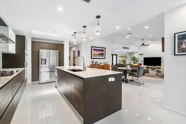 kitchen featuring hanging light fixtures, sink, ceiling fan, stainless steel fridge with ice dispenser, and dark brown cabinetry