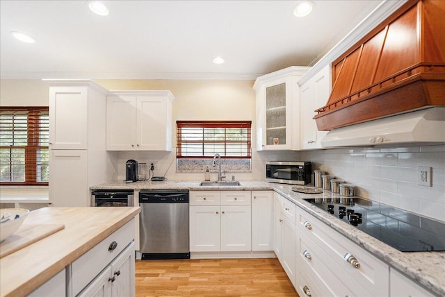 kitchen featuring a sink, appliances with stainless steel finishes, white cabinets, and ornamental molding