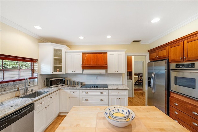 kitchen featuring premium range hood, visible vents, a sink, appliances with stainless steel finishes, and decorative backsplash