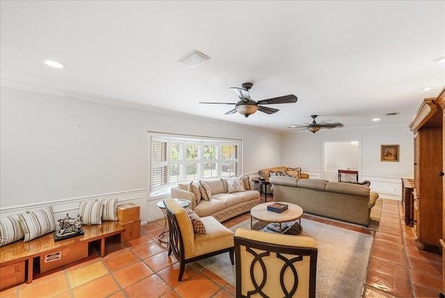 living room featuring visible vents, a wainscoted wall, recessed lighting, crown molding, and a decorative wall