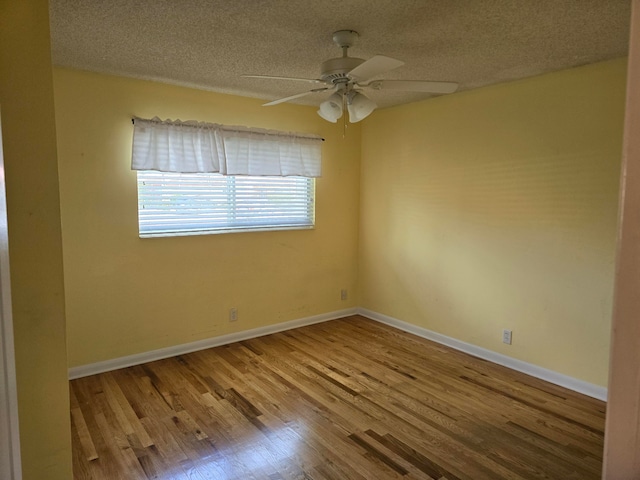 empty room with ceiling fan, hardwood / wood-style flooring, and a textured ceiling