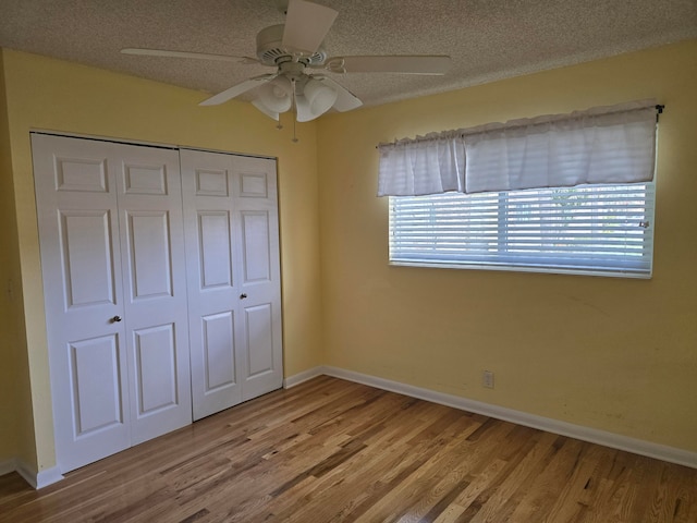 unfurnished bedroom featuring ceiling fan, a closet, and wood-type flooring