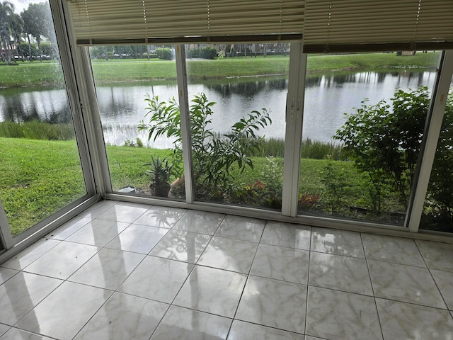 unfurnished sunroom featuring a water view