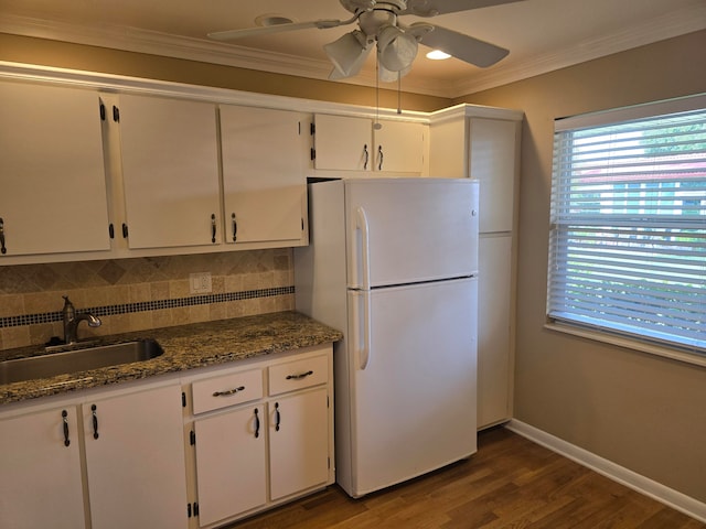 kitchen with white fridge, white cabinetry, tasteful backsplash, sink, and ceiling fan