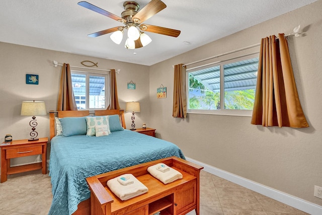 bedroom featuring a textured ceiling, ceiling fan, and light tile patterned floors