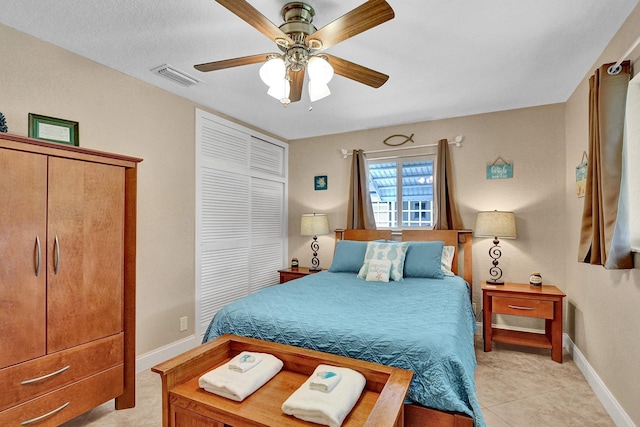 tiled bedroom featuring a textured ceiling, ceiling fan, and a closet