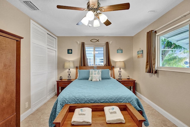 tiled bedroom featuring ceiling fan and a closet