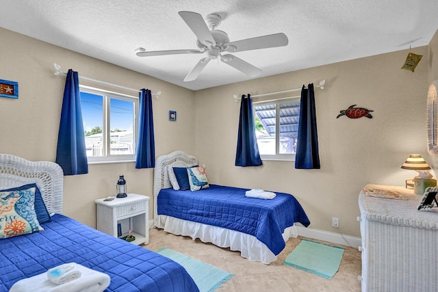 bedroom with a textured ceiling, light tile patterned floors, and ceiling fan