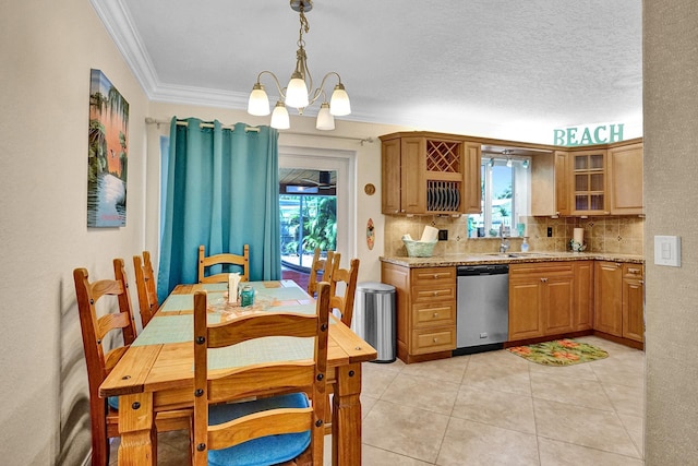 kitchen with crown molding, dishwasher, light stone counters, sink, and hanging light fixtures