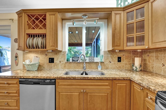 kitchen with appliances with stainless steel finishes, light stone counters, sink, and decorative backsplash