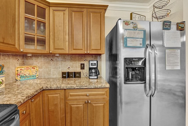 kitchen with stainless steel fridge with ice dispenser, stove, ornamental molding, and light stone countertops