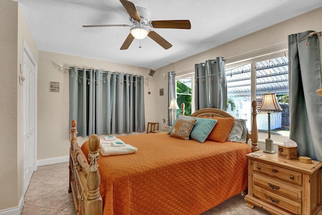 tiled bedroom featuring a textured ceiling and ceiling fan