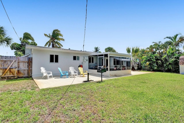 rear view of property featuring a patio area and a lawn