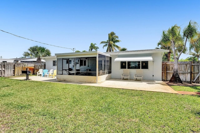 back of property with a patio area, a yard, and a sunroom