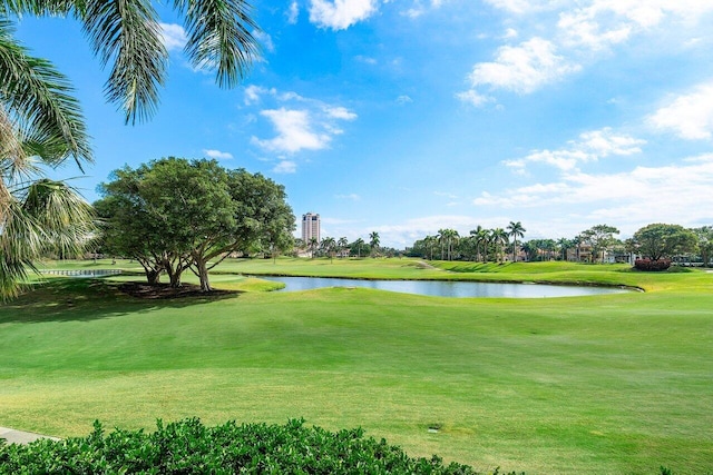 view of community featuring a water view, golf course view, and a yard