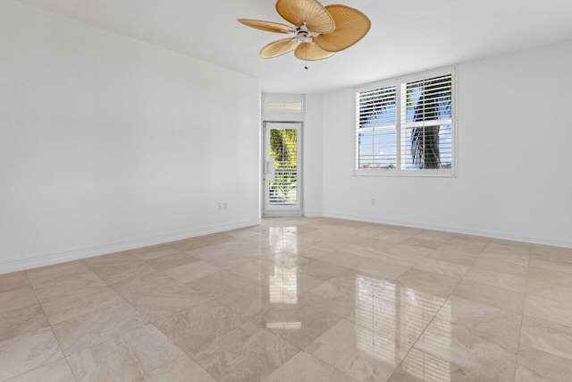 empty room with ceiling fan and baseboards