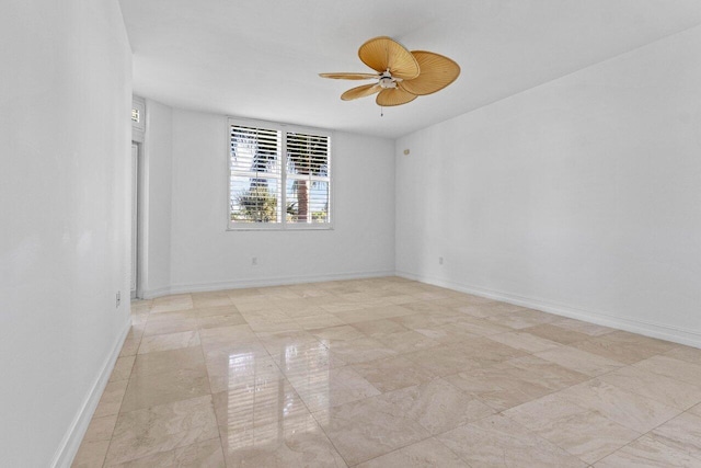 spare room featuring ceiling fan and baseboards