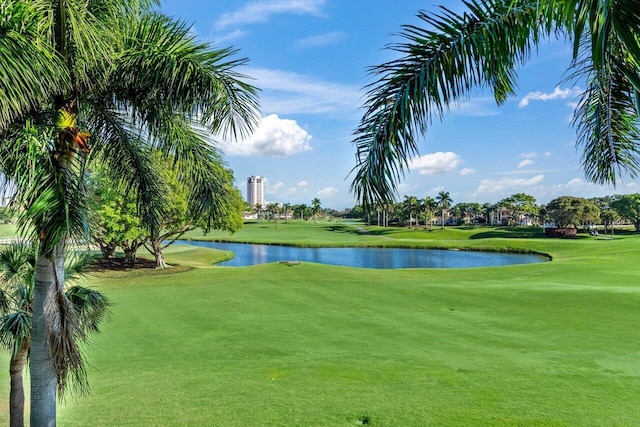 surrounding community with view of golf course, a lawn, and a water view