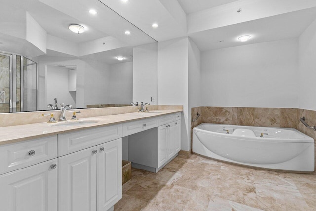 bathroom featuring double vanity, a sink, and a bath