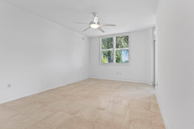 unfurnished room with ceiling fan and baseboards